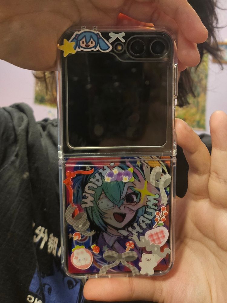 capinha transparante customizada de samsung flip 5 com adesivos da hatsune miku, adesivos de lacinhos vermelhos e cinzas, dois ursinhos e alguns frutos.