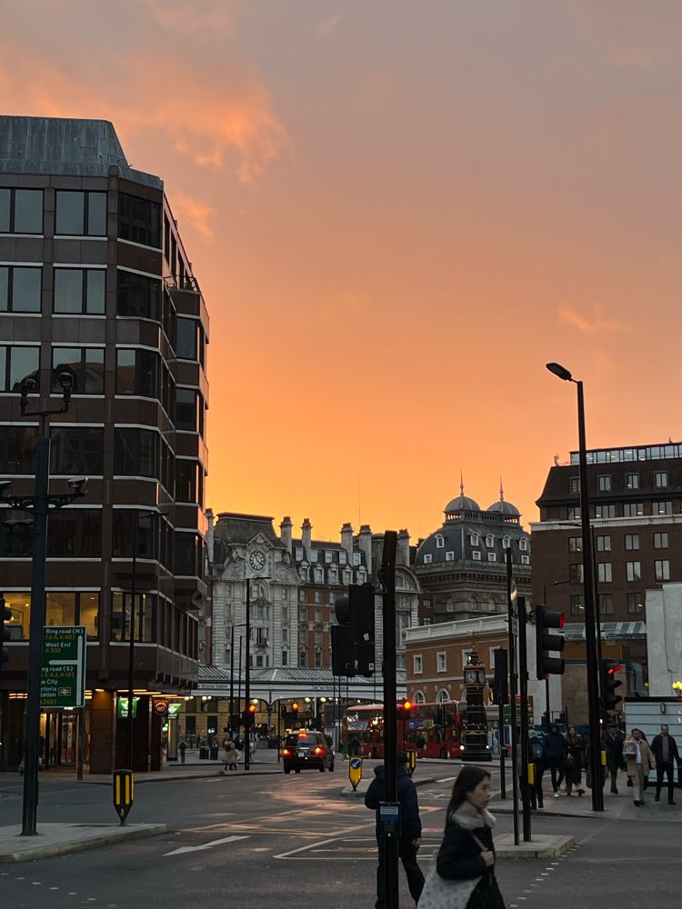 A pretty sunset over a London street. The sky is clear and a golden yellow.