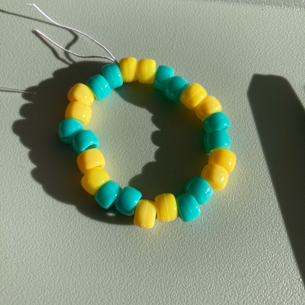 A bracelet with two yellows and two turquoise beads alternating.