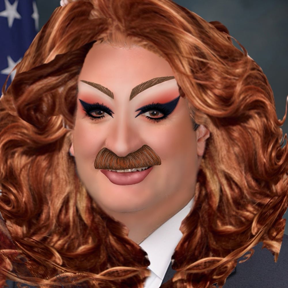 A headshot of Raphael “Ted” Cruz, a United States Senator representing Texas. Raphael is a white middle aged man, he is wearing a curly ginger wig and mustache. His makeup is in the style of drag queen Pattie Gonia, with Hawk like brows, red eyeshadow, and batwing liner. 