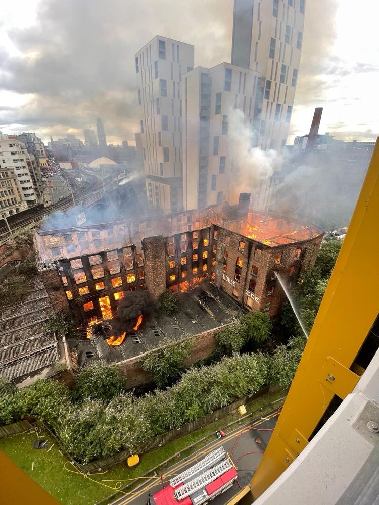 Old cotton mill building completely on fire.