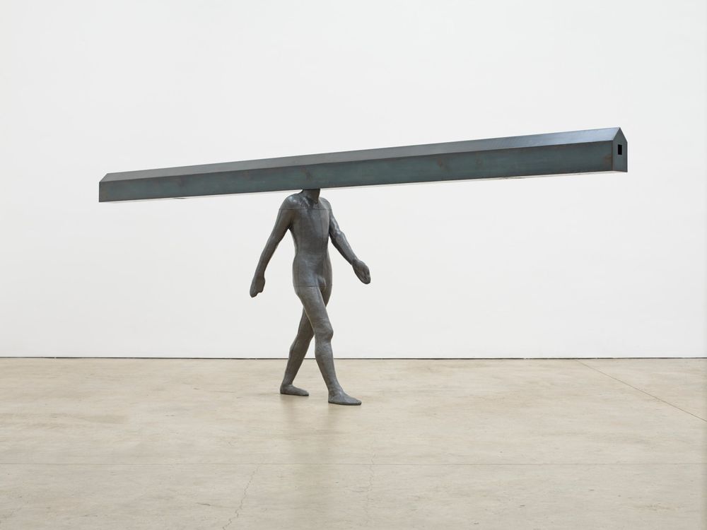 Figural sculpture in which figure's head is replaced by a house-shaped beam