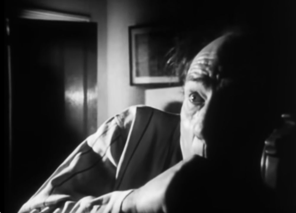 Black and white image of Michael Hordern as Parkins looking off screen, terrified.