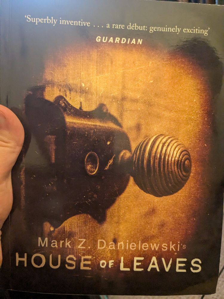 The cover of House of Leaves by Mark Z. Danielewski - a sepia toned photograph of an ornate doorknob with scratches on the film