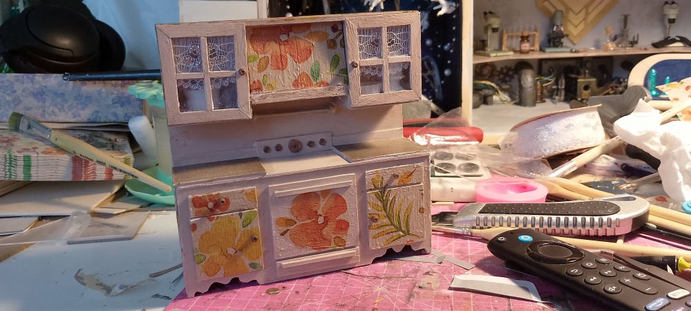 A Photo of a Made from Scratch Dollhouse kitchen. It has flowery decoupage on it.