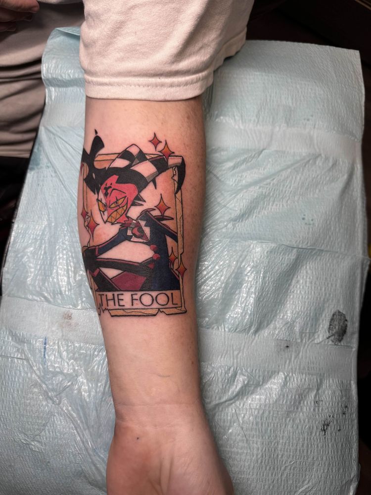 Tattoo of Blitzø from Helluva Boss as the tarot card The Fool on a white person's forearm