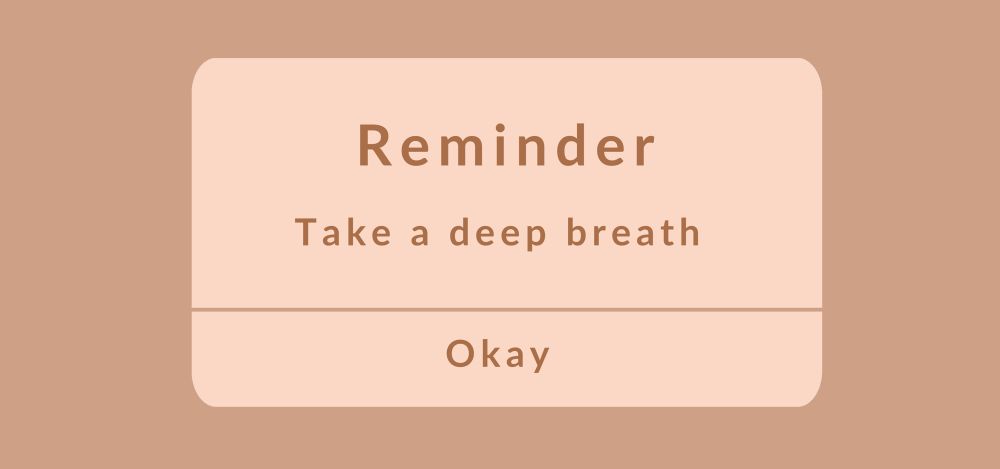 A brown and tan box that says REMINDER: take a deep breath okay. 