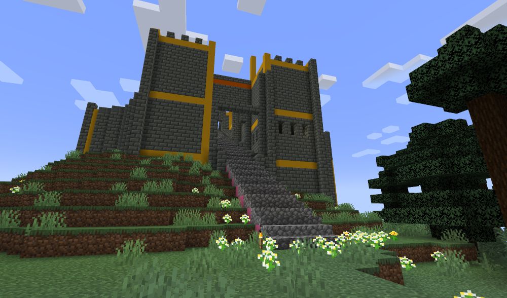 #Minecraft screenshot - front view of a new building under construction, on top of a hill - it's made of tuff bricks and it's a barbican or fortified gate. there's a long set of cobblestone steps leading up and into it.