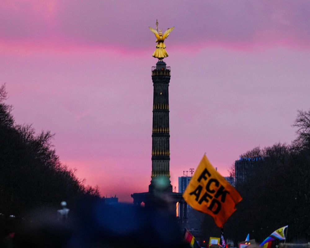 Die Berliner Siegessäule Demonstrationszug und einer Fahne mit der Aufschrift FCK AFD