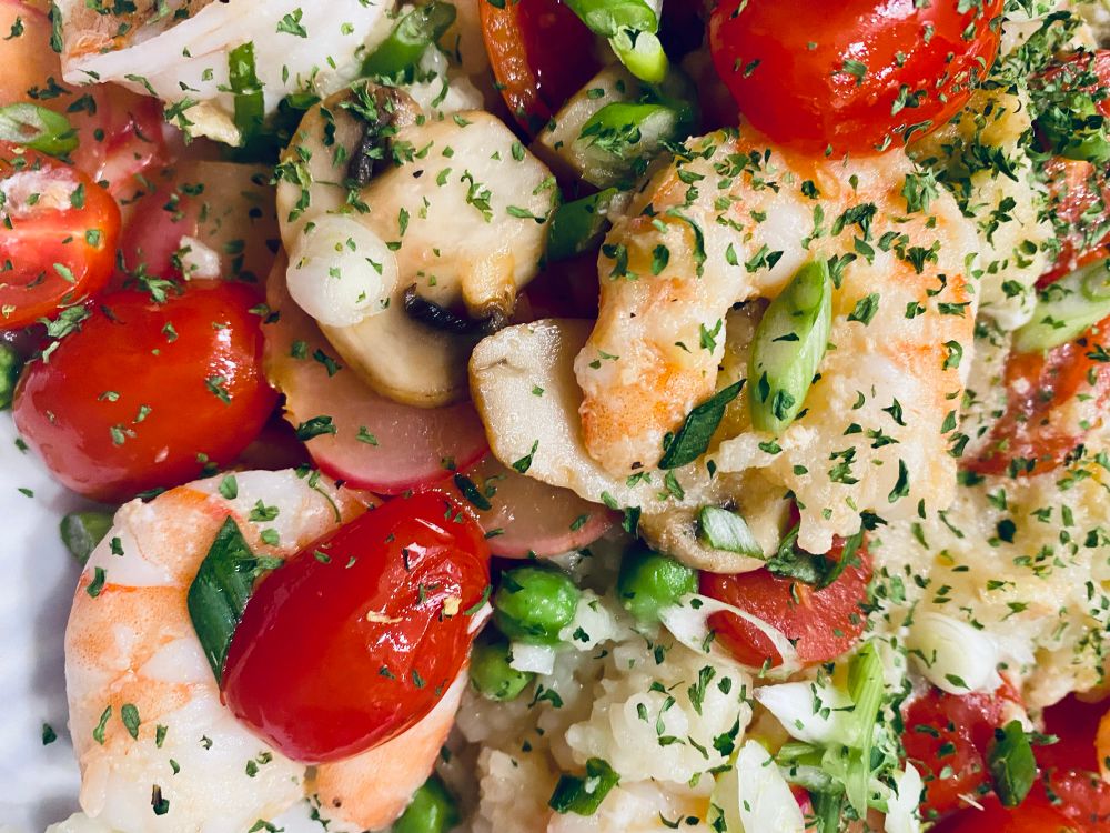 Alt Text:
A colorful, low-fat dinner featuring sautéed jumbo shrimp, cherry tomatoes, radishes, white mushrooms, green peas, and creamy Arborio rice. Garnished with fresh green onions and parsley, the dish looks vibrant and indulgent, yet contains only 1.5g fat per plate. Here’s the recipe:

Ingredients:
	•	Jumbo shrimp (~8 per plate)
	•	Arborio rice (1/3 cup per plate, cooked with Better Than Bouillon broth)
	•	Cherry tomatoes (halved)
	•	Radishes (thinly sliced)
	•	White mushrooms (sautéed)
	•	Green peas
	•	Fresh green onions and parsley for garnish
	•	Grated ginger, garlic powder, onion powder, and liquid aminos for seasoning
	•	Lemon juice and fat-free avocado spray

Instructions:
	1.	Cook Arborio rice in 3 cups broth (Better Than Bouillon) until creamy; stir in peas, grated ginger, and liquid aminos.
	2.	Sauté mushrooms, radishes, and cherry tomatoes in fat-free avocado spray until tender.
	3.	Cook shrimp (1 min per side) with garlic and onion powder, then squeeze with lemon juice.
	4.	Plate rice, top with vegetables and shrimp, and garnish with green onions and parsley.

A dish that’s low-fat, high-flavor, and completely homemade!