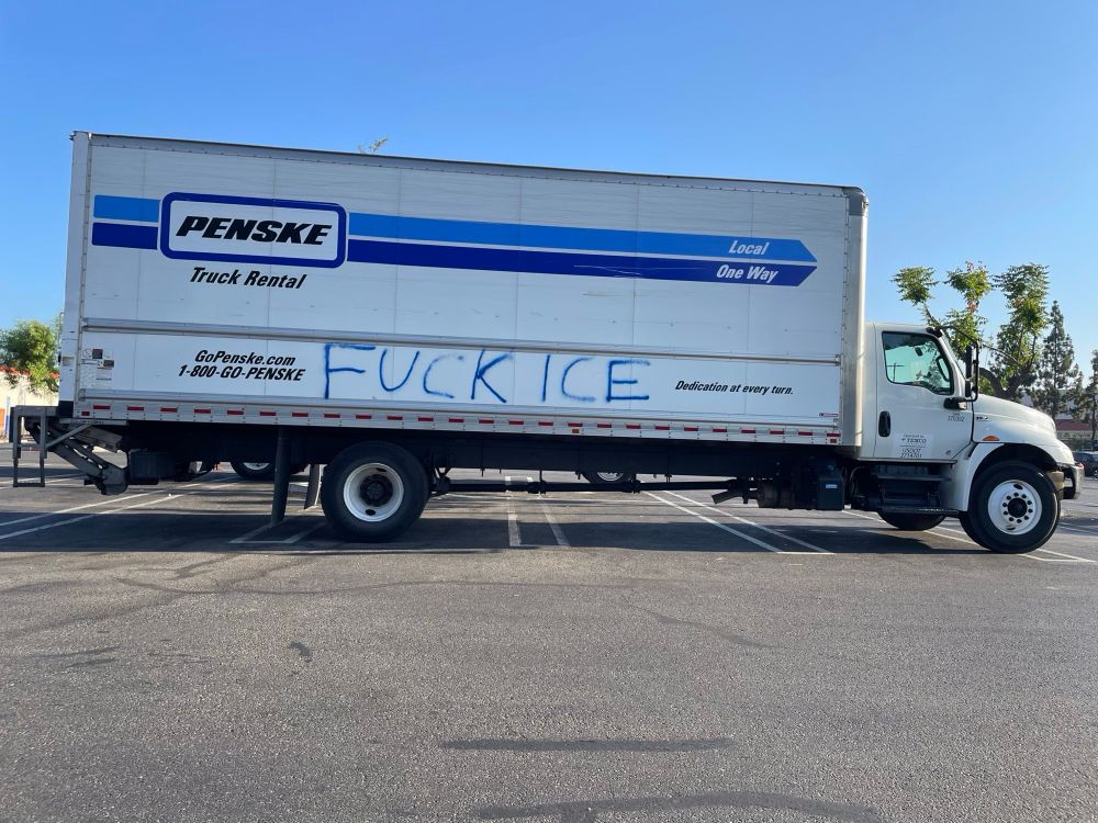 A Penske truck in the Home Depot parking lot has Fuck ICE spray painted on the side