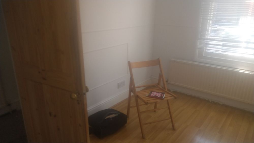 A photograph of a mostly empty room. A copy of A Nazi Word for a Nazi Thing lies on a tatty folding chair I found in an alcove under the stairs. 