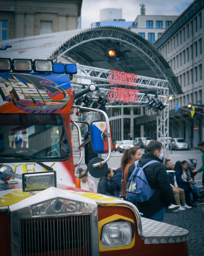 Ein philippinischer Jeepney vor einer Bühne auf dem Roßmarkt. 