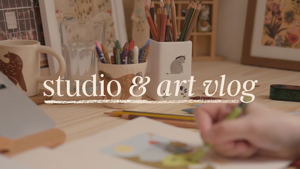 A YouTube thumbnail showing a photo of my hand drawing in a sketchbook with pots filled with pastels and colored pencils in the background.