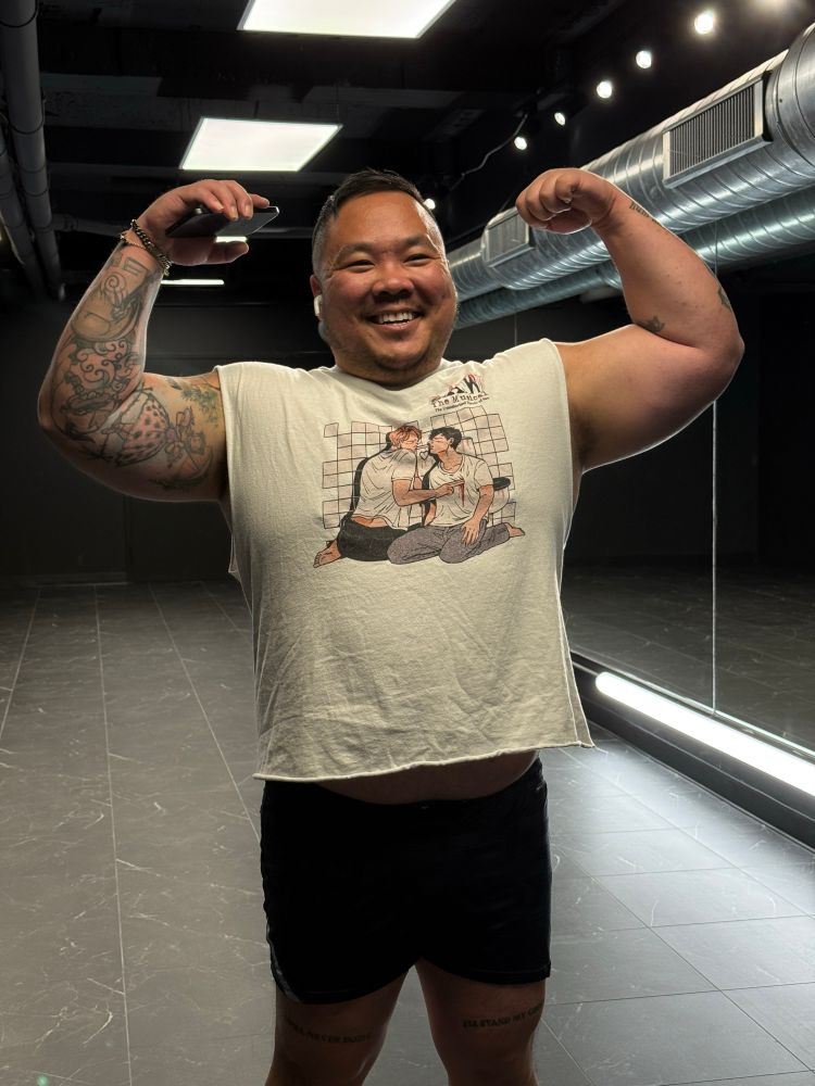 Danny flexing double biceps with a saw the musical shirt on 