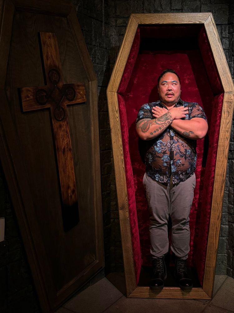 Danny in a coffin with his hands crossed his body 