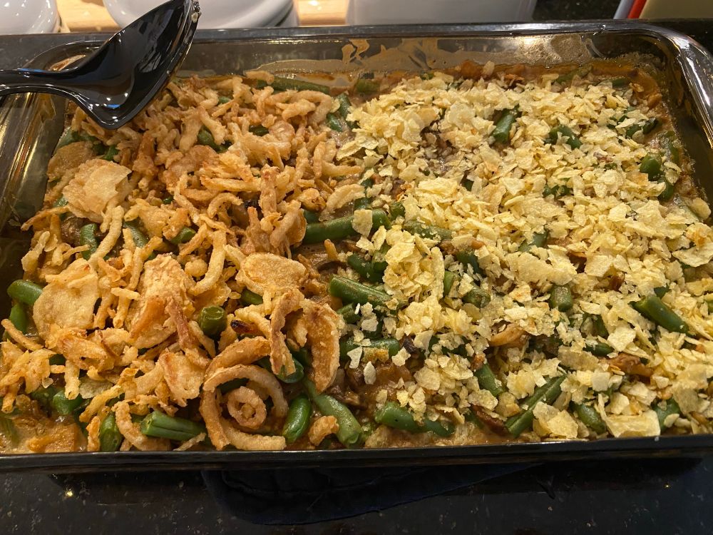 A green bean casserole topped with fried onions on the left and crushed potato chips on the right. There is no no-man’s land!