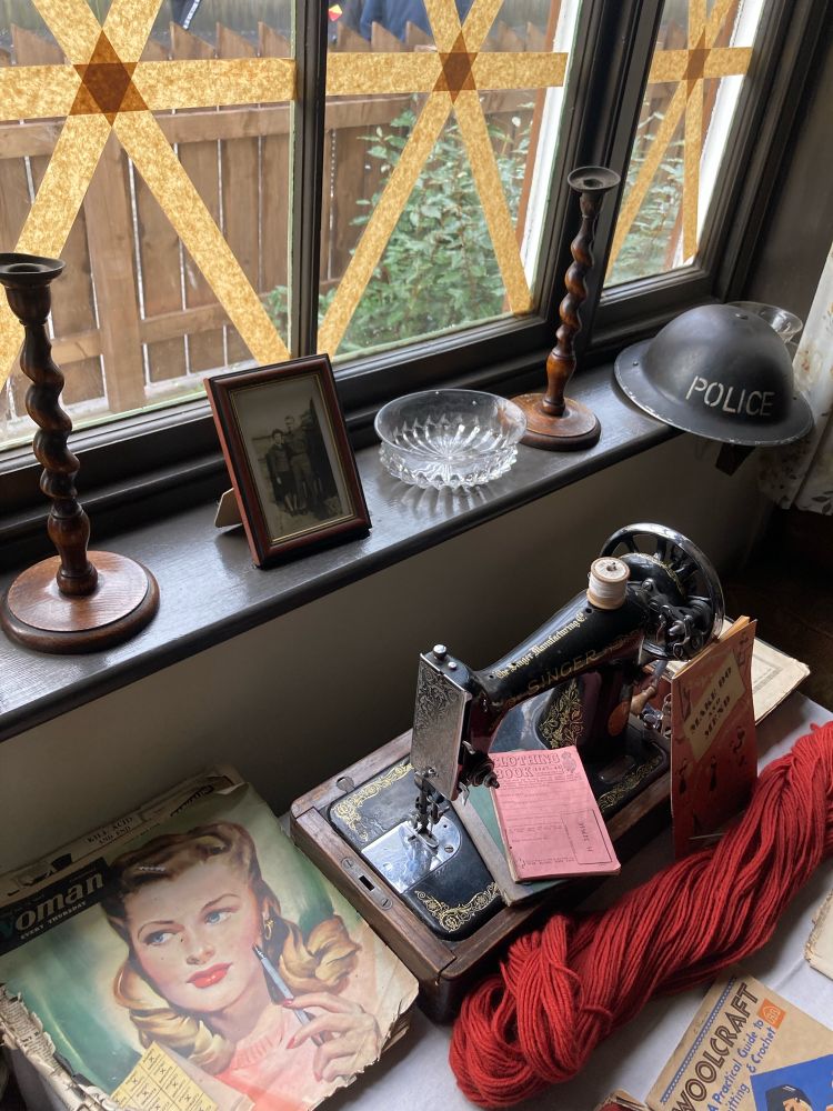 inside of a house, assortment of  decorations, a sewing machine and knitting patterns from c.1950s