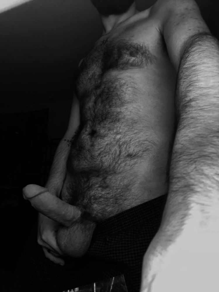 Jay standing shirtless with their hard erect dick and full balls hanging out the top of their boxers