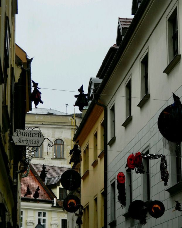 Halloween decorations adorn the buildings on a narrow street