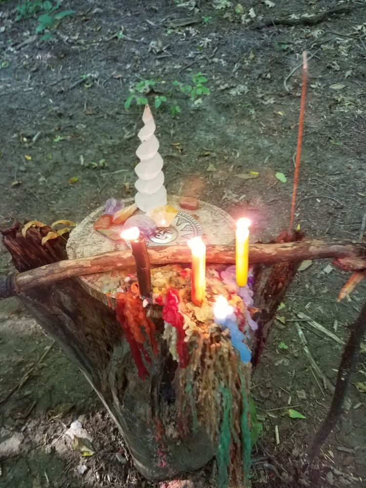 An altar in the woods on a tree stump

