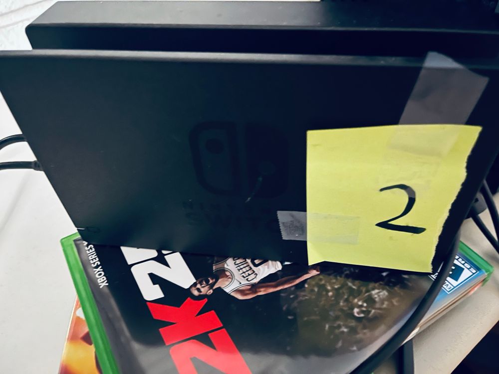Nintendo Switch affixed with a piece of paper with the number two written on it. 