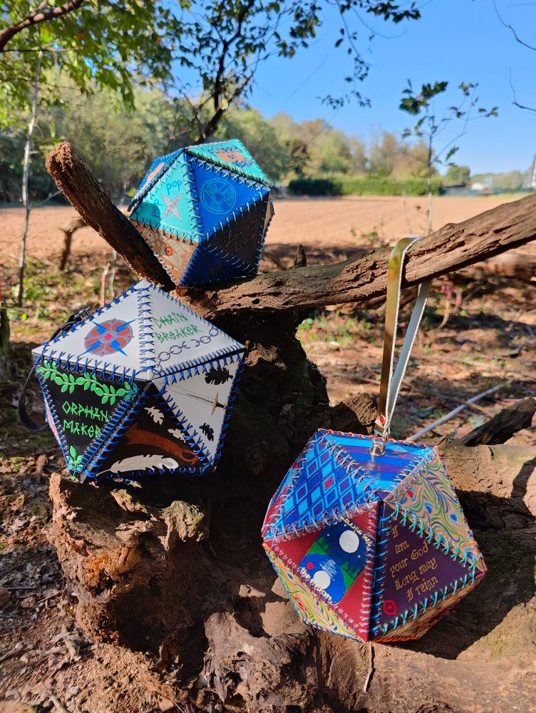 Beau, Yasha and Mollymauk dice bags all together on a big branch 