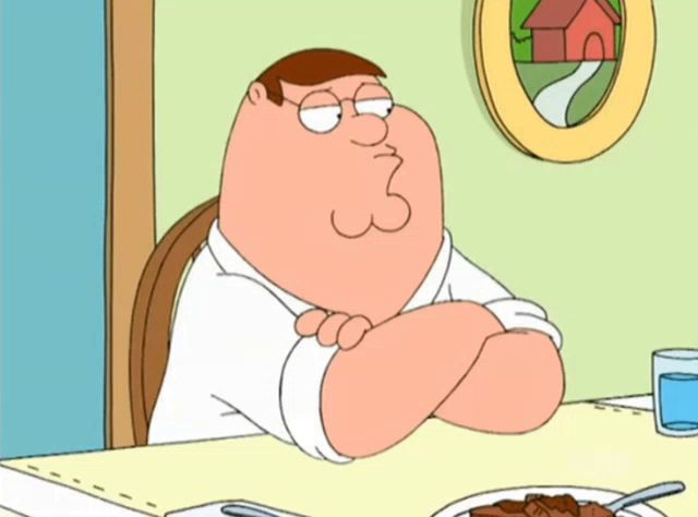 peter griffin sits at a table with his arms crossed