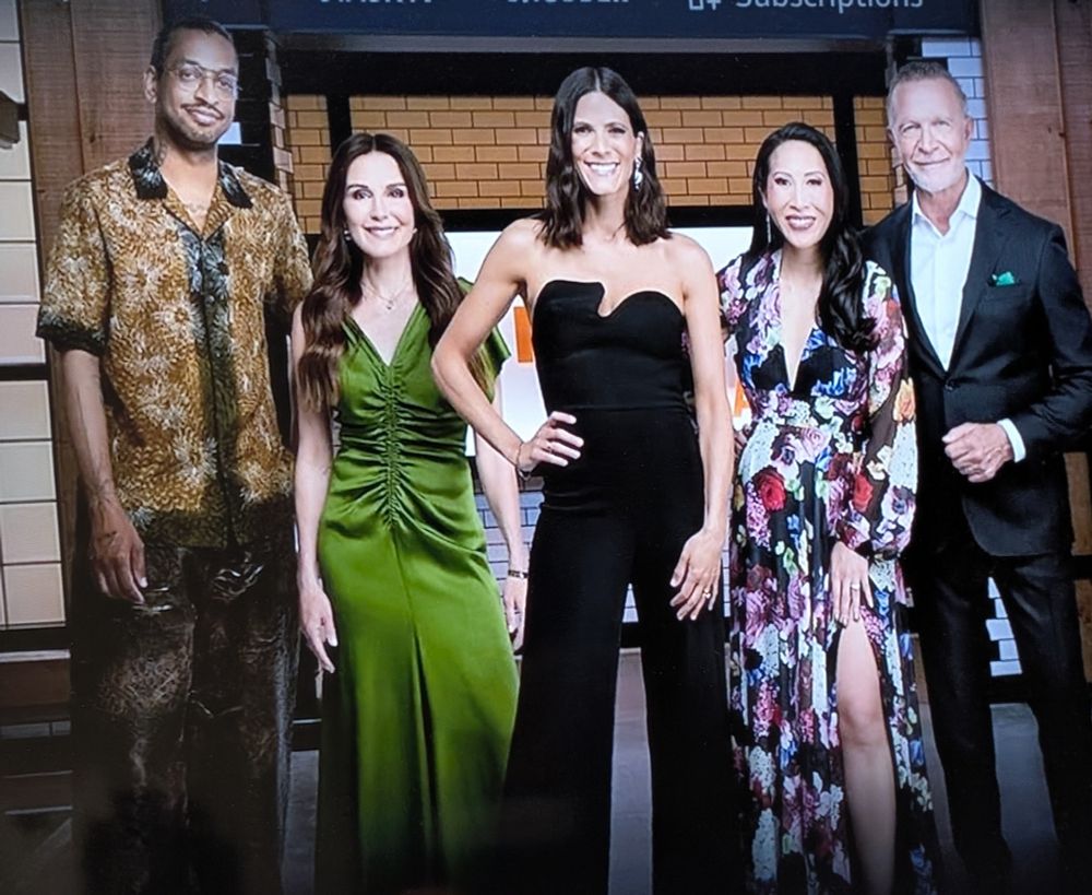 A promo photo of the hosts/stars of Top Chef Canada. Everyone has a weird shape or texture or something that makes their outfit seem slightly off. Except the guy on the far right who just looks like a normal GenAI Suit Guy.