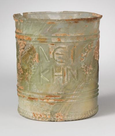 A Roman glass beaker with inscription "Seize the victory!" in ancient Greek flanked by 2 pairs of wreaths. 