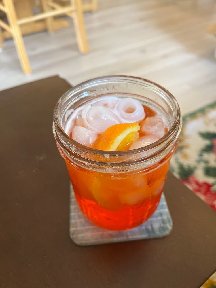 aperol spritz in a ball jar with ice and an orange slice