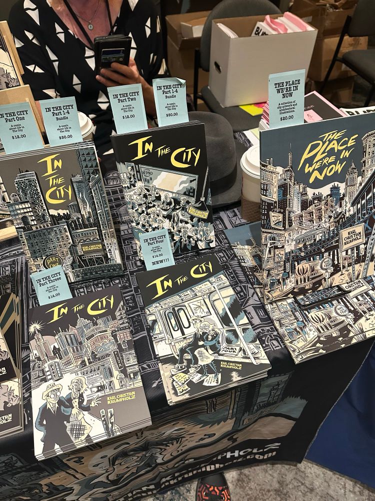A close up of an expo table loaded with books and comics.