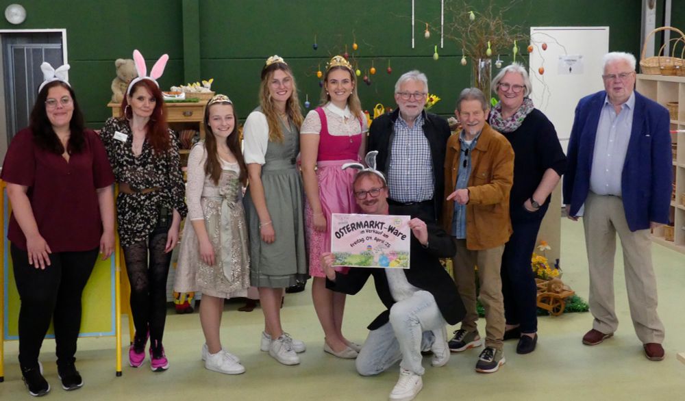 Eröffnungsschnappschuss: Marina & Jasmin vom Kassenteam und der Warenannahme, die Weinprinzessinen Johanna aus Rödelsee, Emily aus Sickershausen und Fiona aus Buchbrunn in Tracht, 2. Bürgermeisterin Astrid Glos und 2. Bürgermeister Manfred Freitag, deutend Vorstand Walter Vierrether und erster Vorstand von APLAWIA e. V. Jürgen Derleth rechts; vorne mit Schild "Ostermarkt-Ware": Geschäftsführer Sebatian Därr