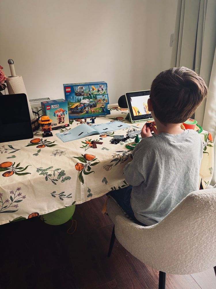 noskus son building lego’s at the table as nosku builds her one piece sets