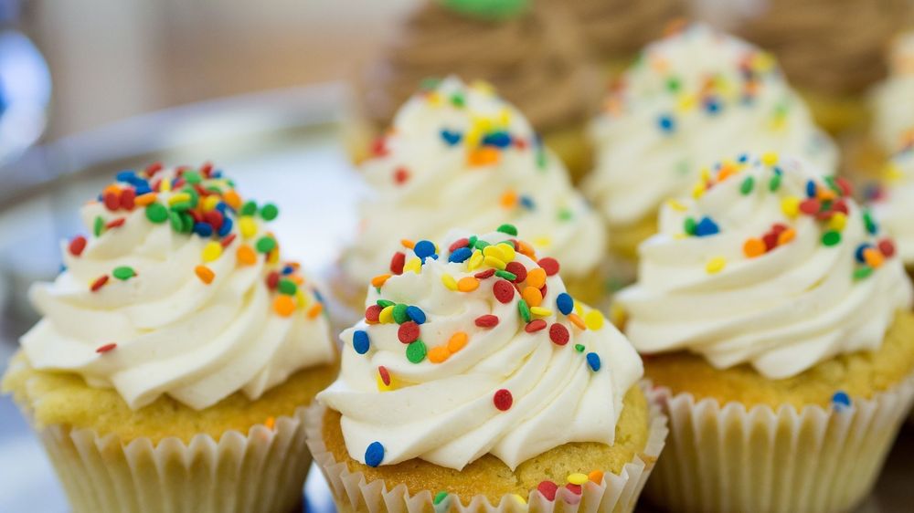 Vanilla iced cupcakes with colourful dot sprinkles