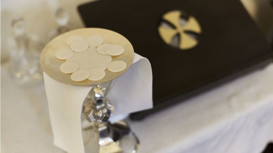 Chalice covered with cloth and wafers in a shallow dish