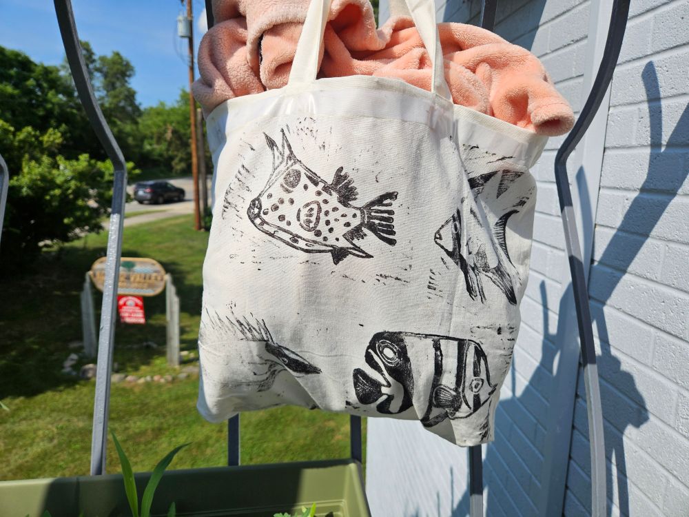 Canvas tote bag with linocut prints of spadefish, rabbitfish, boxfish, and butterfly fish