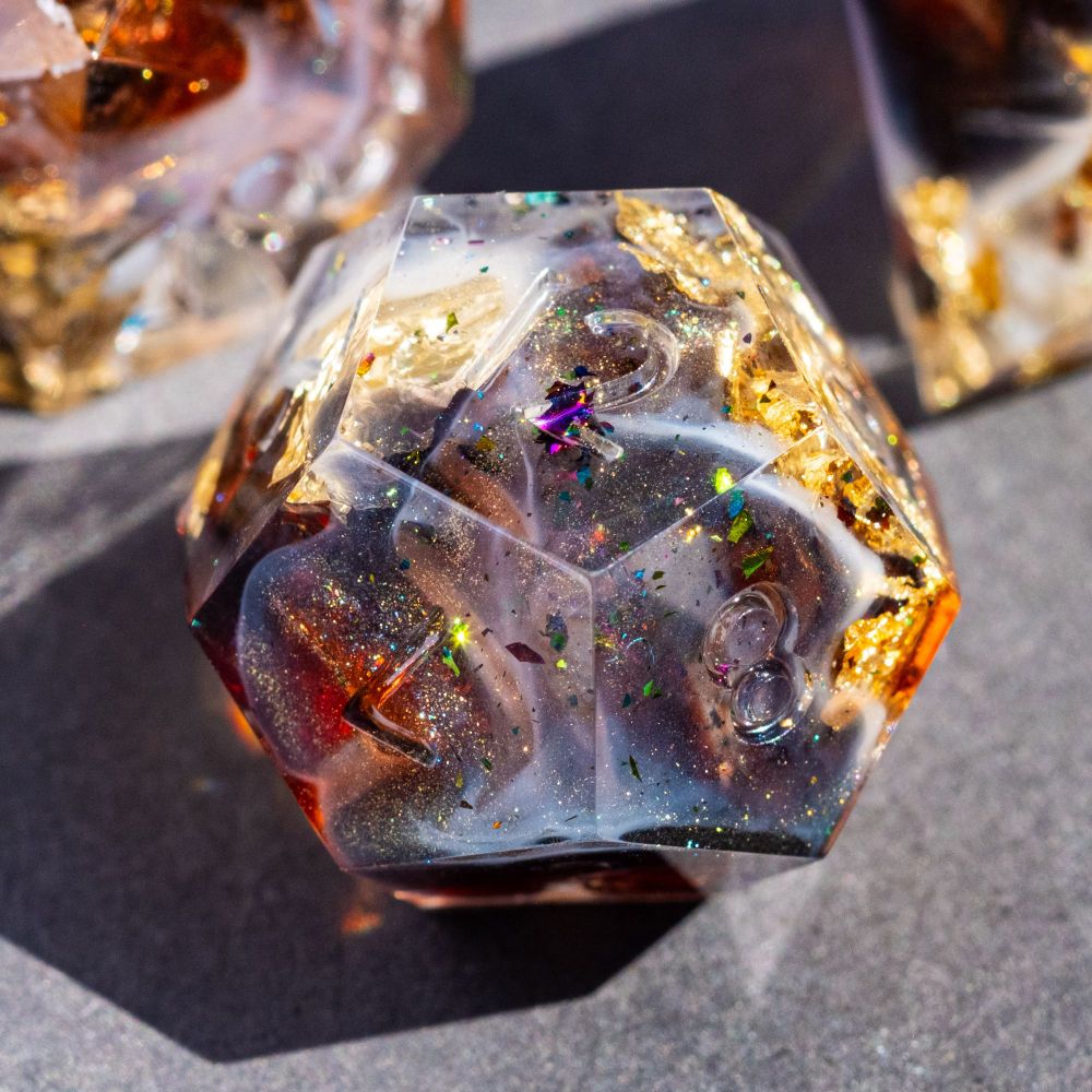 A D12 with gold foil and swirls of white and various shimmery colours