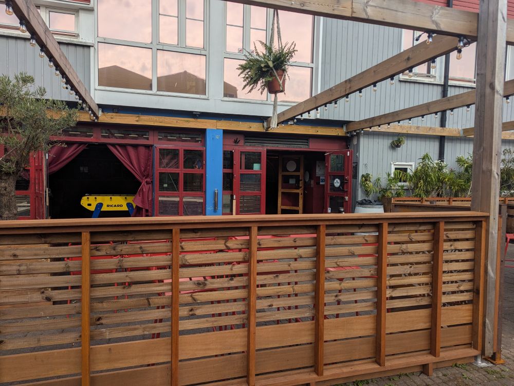 Bar front obscured by fence.