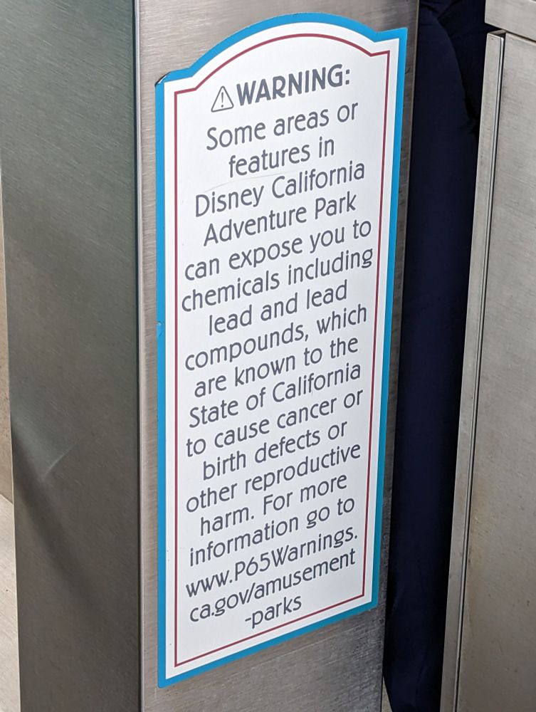 Photo of a health warning at Disneyland indicating features at the park are known by the State of California to cause cancer or birth defects.
