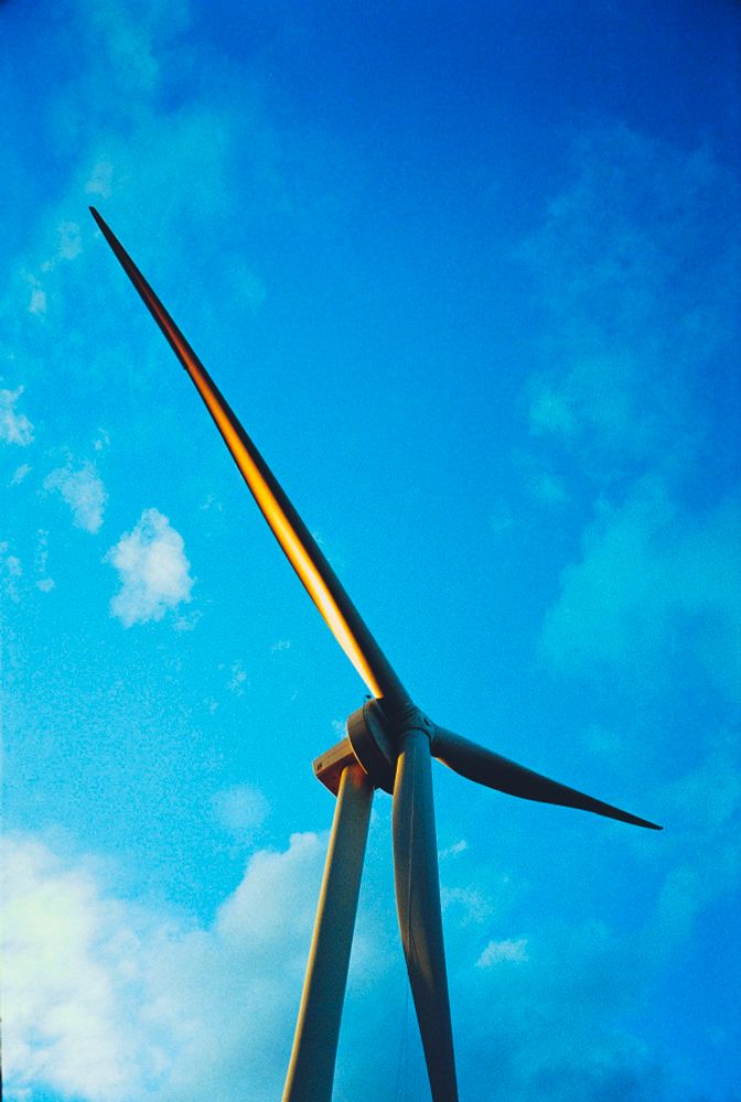 夕日を浴びた風車を真下から見上げる