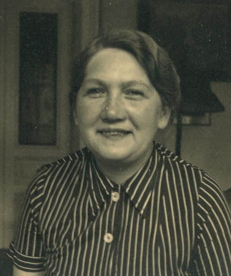 Portrait of a woman, smiling and wearing a striped shirt.