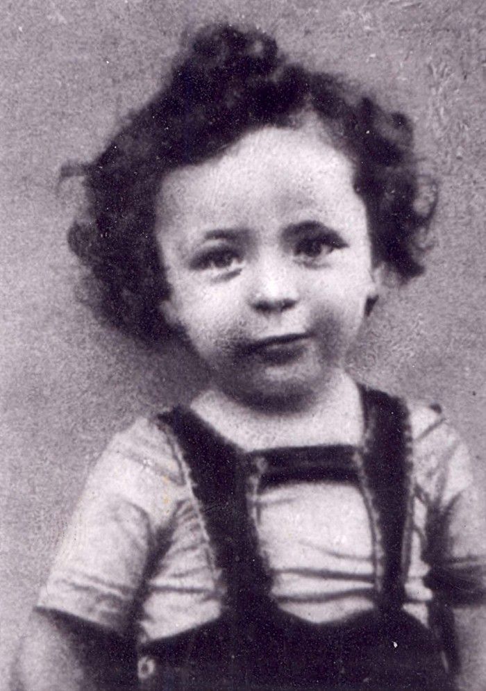 Black and white portrait of a young boy with curly hair.