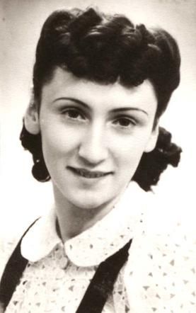 Vintage black-and-white photo of a smiling woman with styled hair and a patterned blouse.