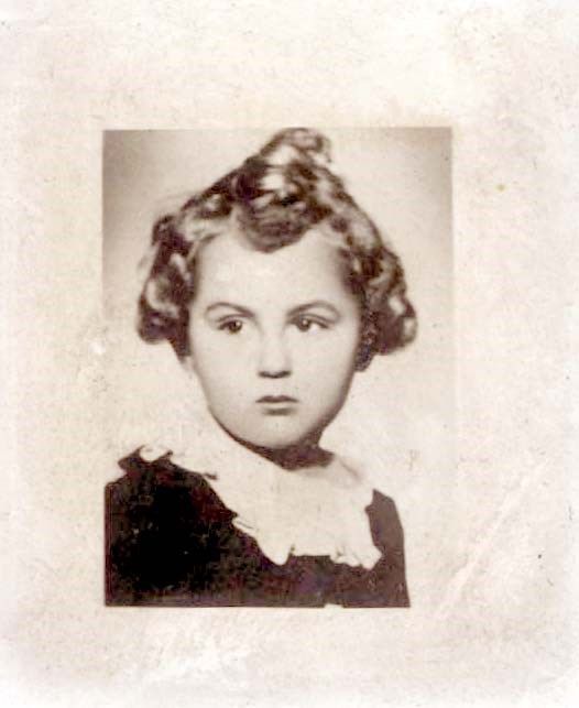 Vintage black and white photograph of a young girl with curly hair wearing a dark dress with a white lace collar