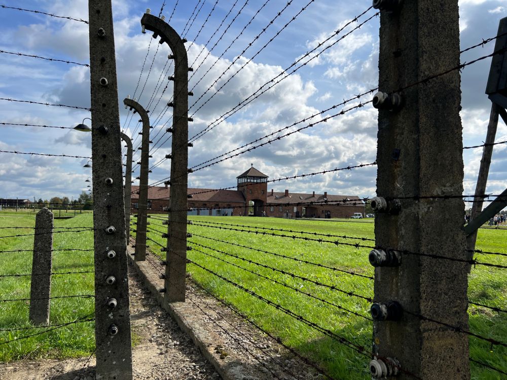 Posts, barbed wire fences and the main gate of the former Auschwitz II-Birkenau camp.