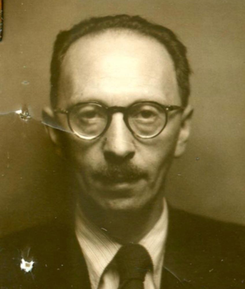 Vintage black-and-white portrait of man in round glasses and a tie.