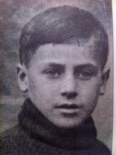Black and white photo of a young boy wearing a turtleneck sweater.
