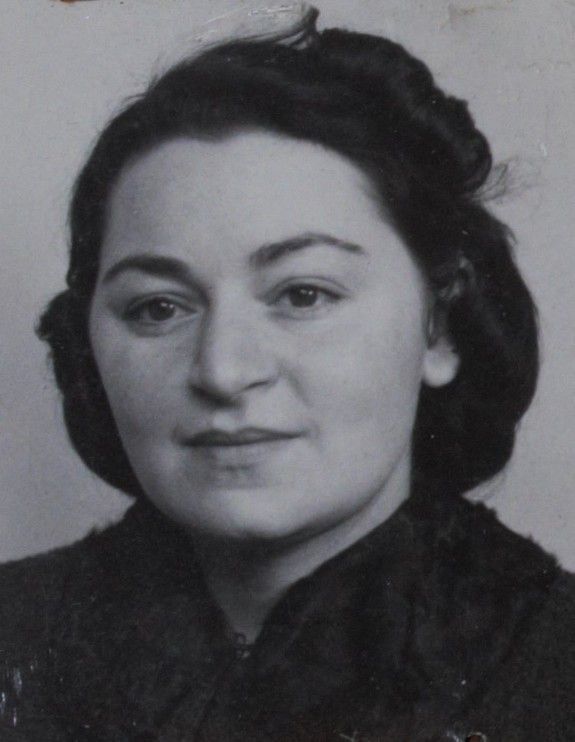 Black and white portrait of a woman with a calm expression, wearing a dark blouse and hair styled in an updo.