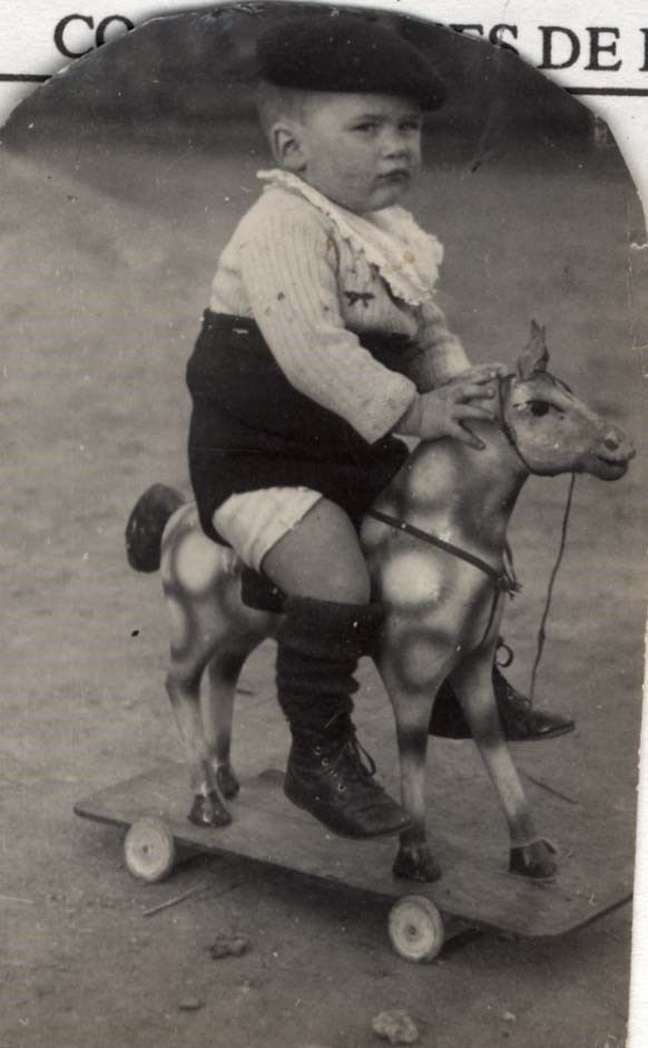 A child rides a toy horse on wheels